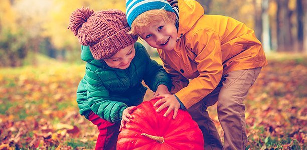 Nutrição infantil: crianças brincando com uma abóbora no frio.