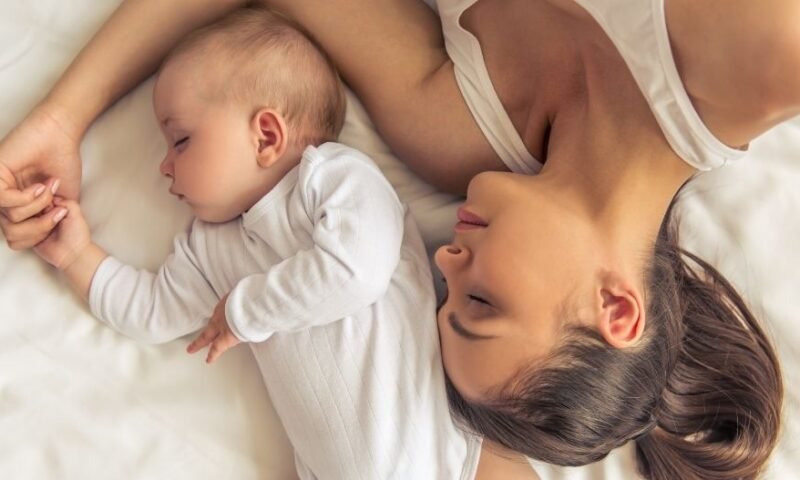 mãe dormindo na cama com seu bebê - Primeira infância