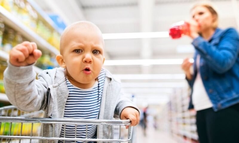 bebê no supermercado com sua mãe e fazendo cara de brabo - Terrible Two