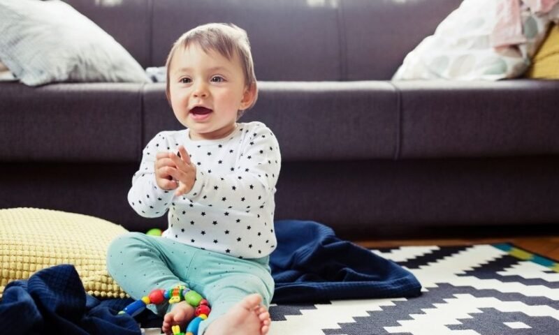 bebê sorridente brincando na sala de estar da casa - desenvolvimento da fala